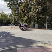 Cross over Park Road North using the pelican crossing.