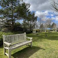 Just beyond the flowers beds we will head right. You may want to stop by the bench on the grass, enjoy the garden space and play the audio.