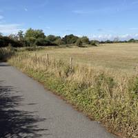 Continue along the road as it curves. Up ahead you may spot a pillbox from here.