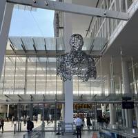 Leave via the station exit ahead, find WE by Jaume Plensa suspended from the Shard. Find the 2nd steel figure at the News Building opposite.