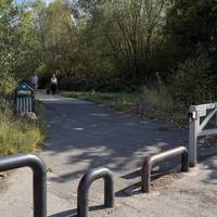 You’ll notice the opening to the park on your left. We are heading into Bold Forest Park. Mind the barriers as you go.