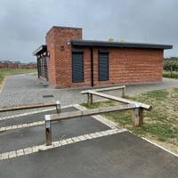 Pass through the wooden barriers and past the community hub.