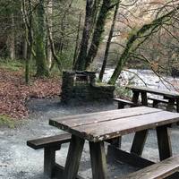 Opposite the car park is a large open space with picnic tables, beside the river