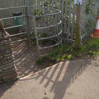 Keep walking until you reach a railway bridge and see a Travis Perkins sign on the right. Turn left through a kissing gate.