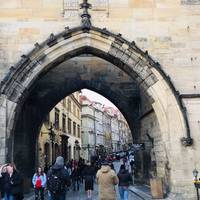 Begin your walk beneath the tower on the Malá Strana side of the famous Charles Bridge (Czech: Karlův Most). Walk up the cobbled street.