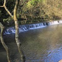 Walk past the lovely little weir on the way to the footbridge river crossing.