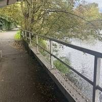 At the bottom of the stairs turn right and walk under the bridge. Continue along the path, which is paved and wide.