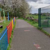 Continue straight ahead passing the play area with the coloured fence on your left.