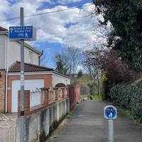 Turn right onto the shared path between houses.