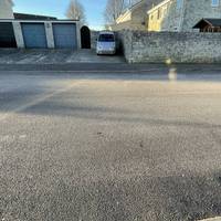 Cross Waterford Park towards some garages where there is a dropped kerb just before the footpath sign. Then turn right towards it.