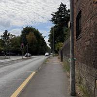 With the bus stop on your left, head along the pavement towards the trees.