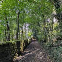 Take the path with the dam on your right and walk uphill up a cobbled path