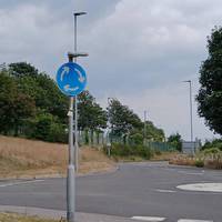 At the roundabout near Carpark B, cross the road and take the footpath between the road markers and the large tree