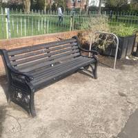 Bench on Clarendon Road faces the shops including greengrocers, butchers, tailors and the pharmacy.
