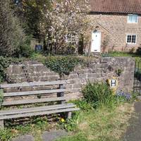 There is a bench here next to beautiful cottages where you could take a moment