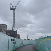 This area of Brent Cross is going under development. Continue past through this boarded off pathway.