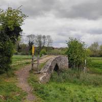 Cross the bridges. This is a Medieval stone packhorse bridge from the 15th century.