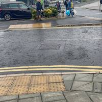 Cross the road at the tactile paving to go left.