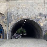 ... to walk underneath the railway tunnel. There are bike racks just here. At the other end turn left again.