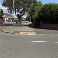 Use the tactile dropped kerb to cross over Norwood Road.