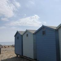 Walk past the blue beach huts and wade over the mouth of the River Char which is popular with families or cross over the wooden foot bridge.