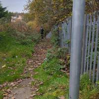 Go slightly left and immediately turn right along a paved path and then down steps away from the road.