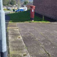 Walk past the postbox and round the back of the shops.