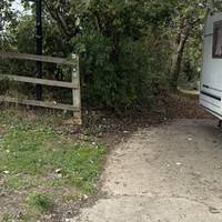 Head past the houses, cars and caravan towards the path signposted.