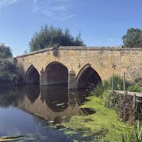 Enter the gravel car park - owned by the pub. You’ll see a grassy area with picnic tables where you can get a good view of the older bridge.