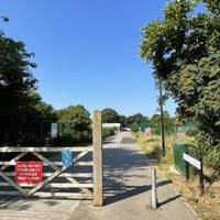 Pass the wooden gate and bollard and onto the wide flat path heading gently downhill.