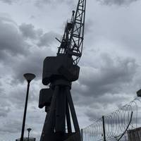 Walk on to the road. You can take a quick detour across the road to view these dockside cranes and a boating club in the old docks.