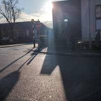 Carefully cross the main road towards the zebra crossing on the opposite side of road