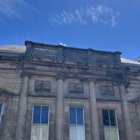 On your left is the neoclassical style, former Lyceum building. It served as England's first subscription library and a newsroom.