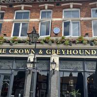 Pass, (or pop in) The Crown and Greyhound public house on your left.