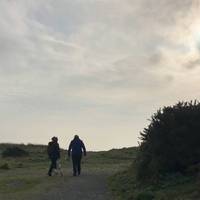 The path rises up towards a grassed-over shingle bank, and the river bends away to the left