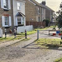 Go through the barrier and along the gravel road passing allotments on your left.