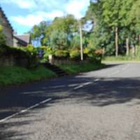 On the bend you will pass houses on your left. Continue uphill past the houses. Use roadside verges if necessary when vehicles pass.