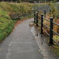 After a path joins from the left, continue along the level path, still with a railing to the right.