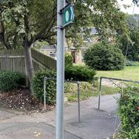 At the footpath marker, pass by the metal barriers and head down the paved path to the right.