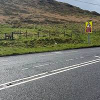 Follow the path up joining Manchester Road. As you reach the sharp bend road sign cross over and cross the stile and bear right.