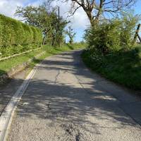 You should be walking past the pub on your right and heading towards a gentle slope.