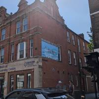 Look up to see the painted mural across the street as you walk down the High Street towards Bedford Town centre.