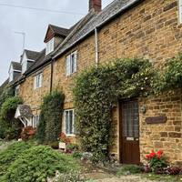 Walk along the front of a short terrace of cottages.
