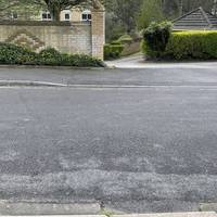 Cross at the dropped curbs on Alcove Road.