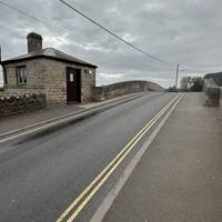 Pass the toll house, keeping on the right side of the road.