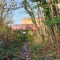 Follow the churchyard perimeter path right, anti-clockwise towards the view of the bus station