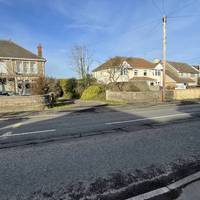 Pass a residential home and then, when safe to do so, cross North Road using a drop kerb from the driveway to 71A towards a telegraph post.