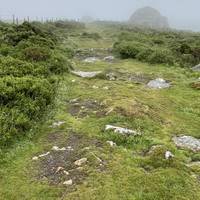 Keep to the right of the fence and head over the rocky path which can be slippery.