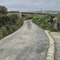 Keep going as you leave the village and walk along the country lane with hedges on either side.