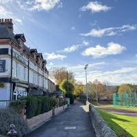 A little further up the road, turn right onto the path, with the athletic track on the right.